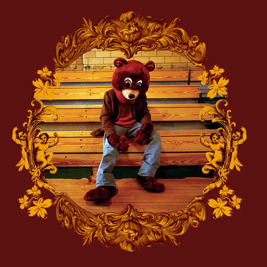 West wearing a bear mascot costume, slouched over on a bench. The image is surrounded by an intricate gold design, all against a brown background.